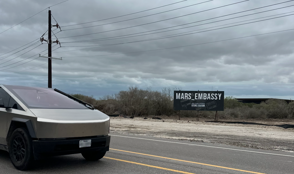 Cybertruck passing the Mars Embassy billboard on approach to Starbase